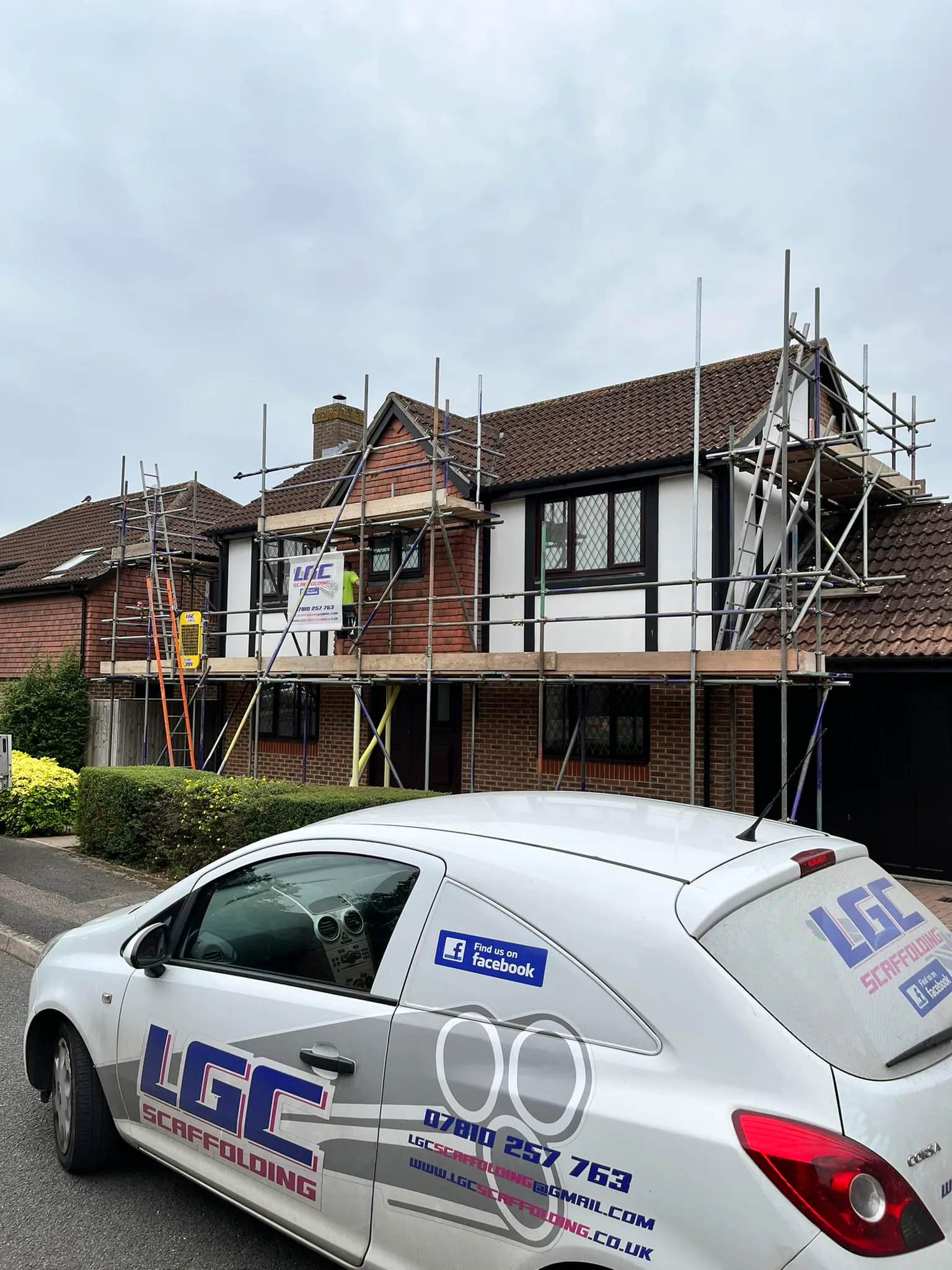 A car parked in front of a house under construction.